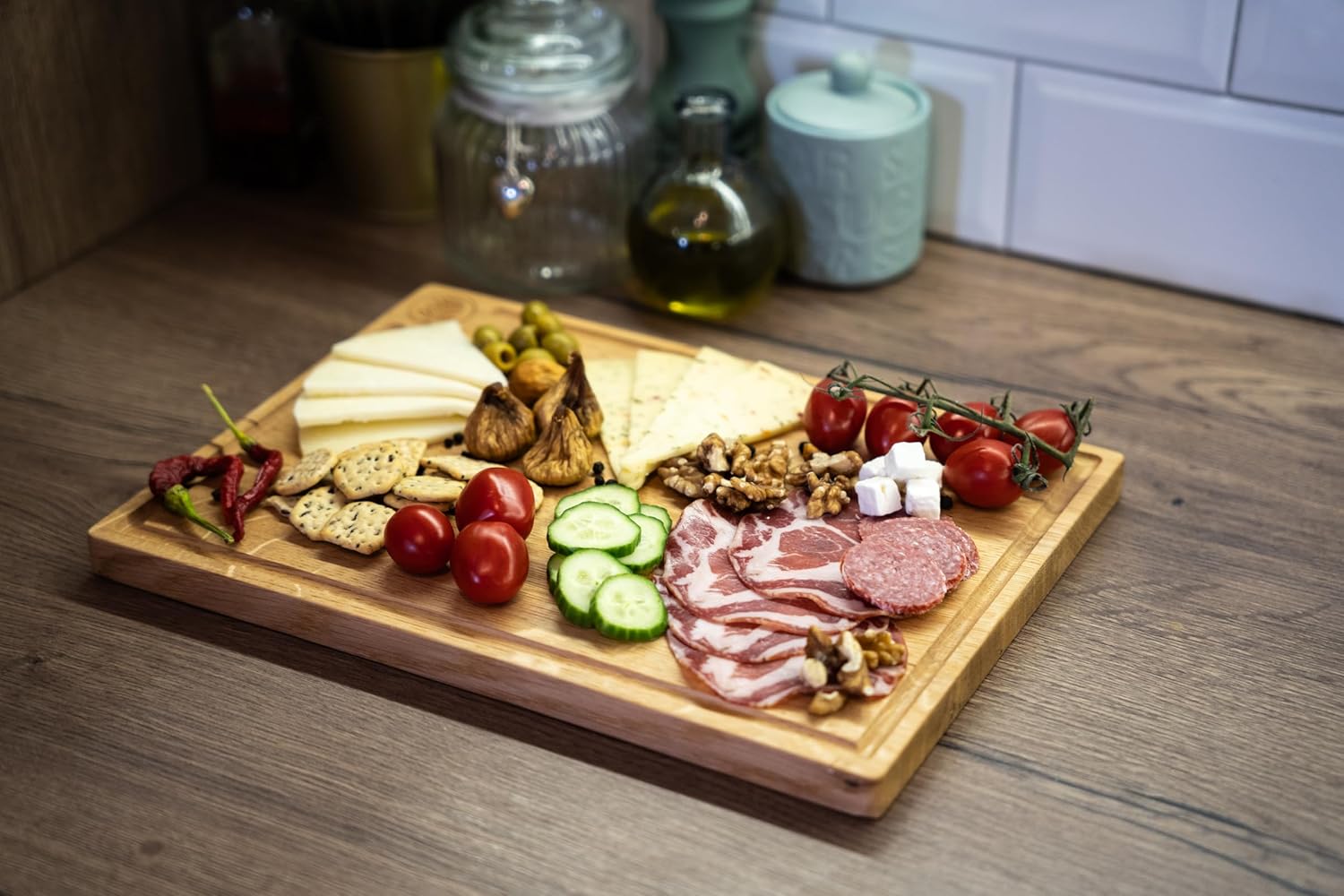 Lumberland Eichen-Schneidebrett reichlich belegt als Servierplatte mit Käse, Schinken, Salami, Tomaten und Nüssen.
